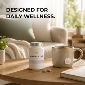 Pureva C+Zinc bottle on wooden table with tea mug, capsules, plant and notebook in cozy home wellness setting