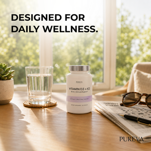 Pureva Vitamin D3 plus K2 bottle arranged on a sunlit wooden table by a window with a glass of water, succulent plant, sunglasses and newspaper, designed for daily wellness lifestyle